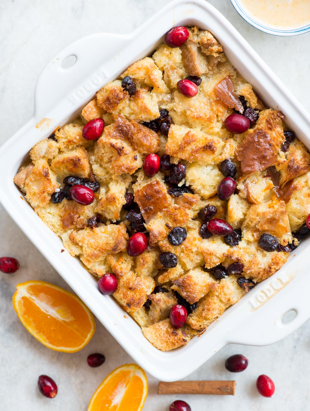 Warm Orange Cranberry Bread Pudding with a gooey custard-like centre and crispy top is a delicious dessert everyone would love. Top it with orange glaze while serving.