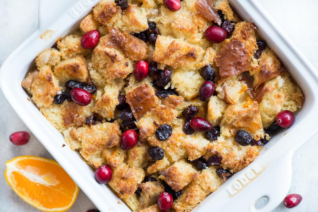 Warm Orange Cranberry Bread Pudding with a gooey custard-like centre and crispy top is a delicious dessert everyone would love. Top it with orange glaze while serving.