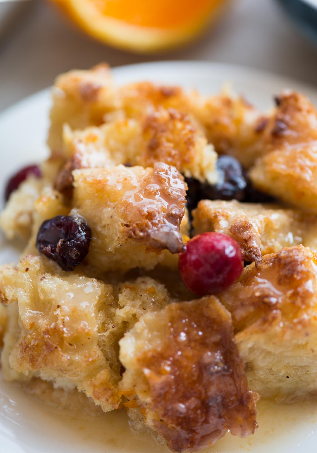 Warm Orange Cranberry Bread Pudding with a gooey custard-like centre and crispy top is a delicious dessert everyone would love. Top it with orange glaze while serving.