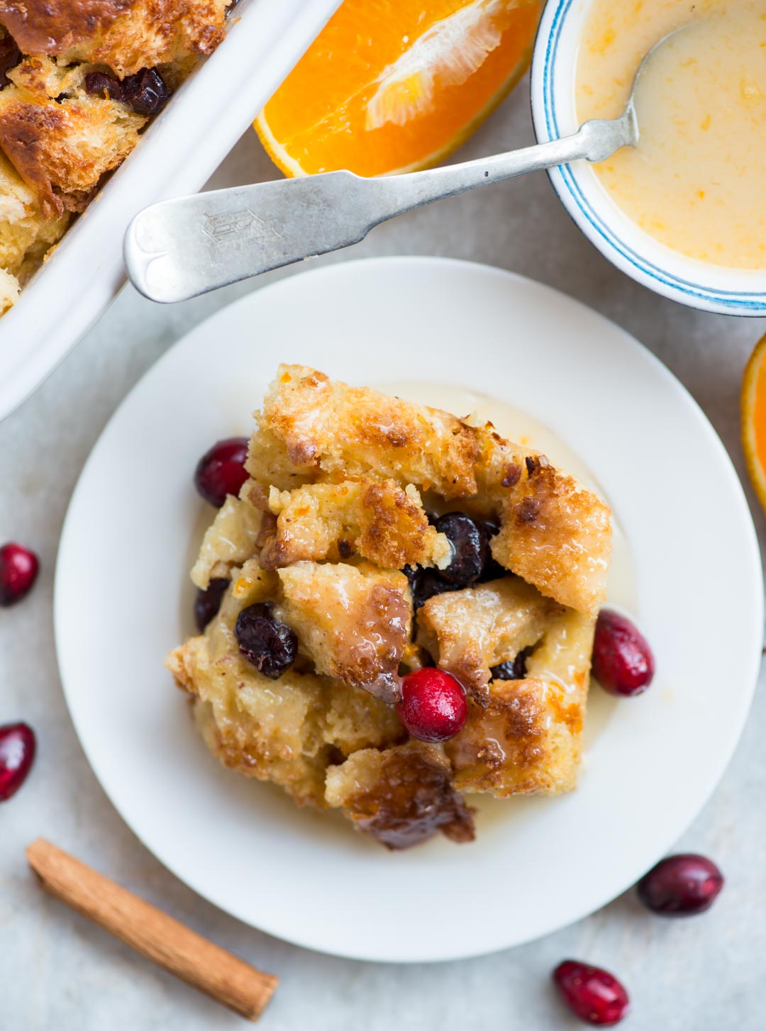 Warm Orange Cranberry Bread Pudding with a gooey custard-like centre and crispy top is a delicious dessert everyone would love. Top it with orange glaze while serving.