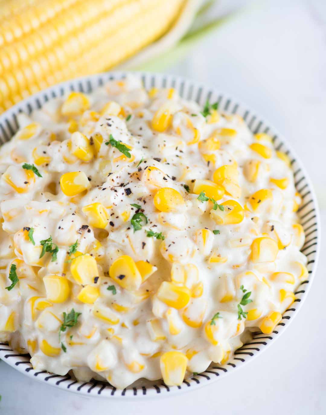 Learn how to make Creamed Corn from scratch. Fresh Corn, butter, flour roux and half& half is all you need to make this easy and creamy creamed corn recipe.