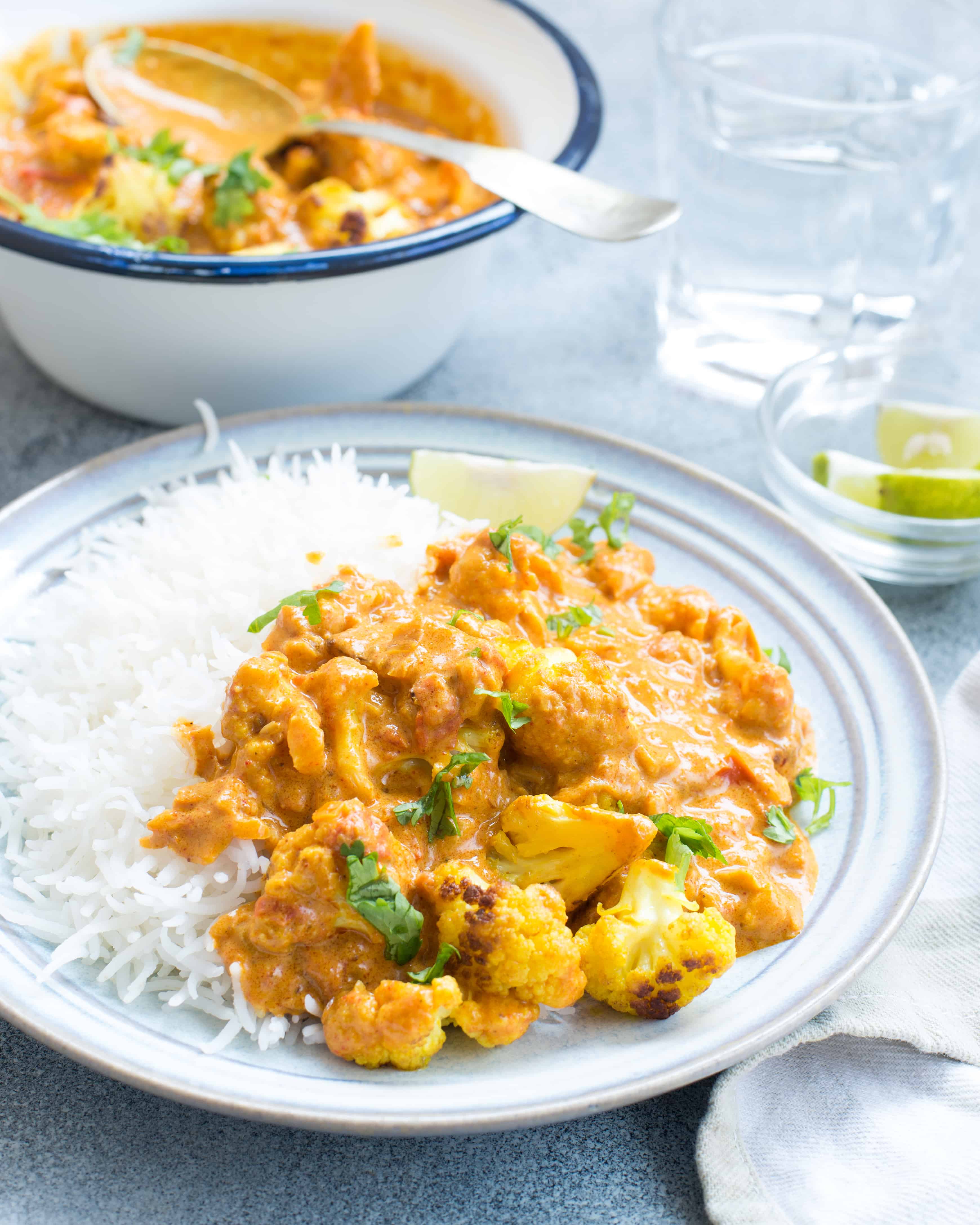 Creamy cauliflower curry is served on a bed of hot white rice.