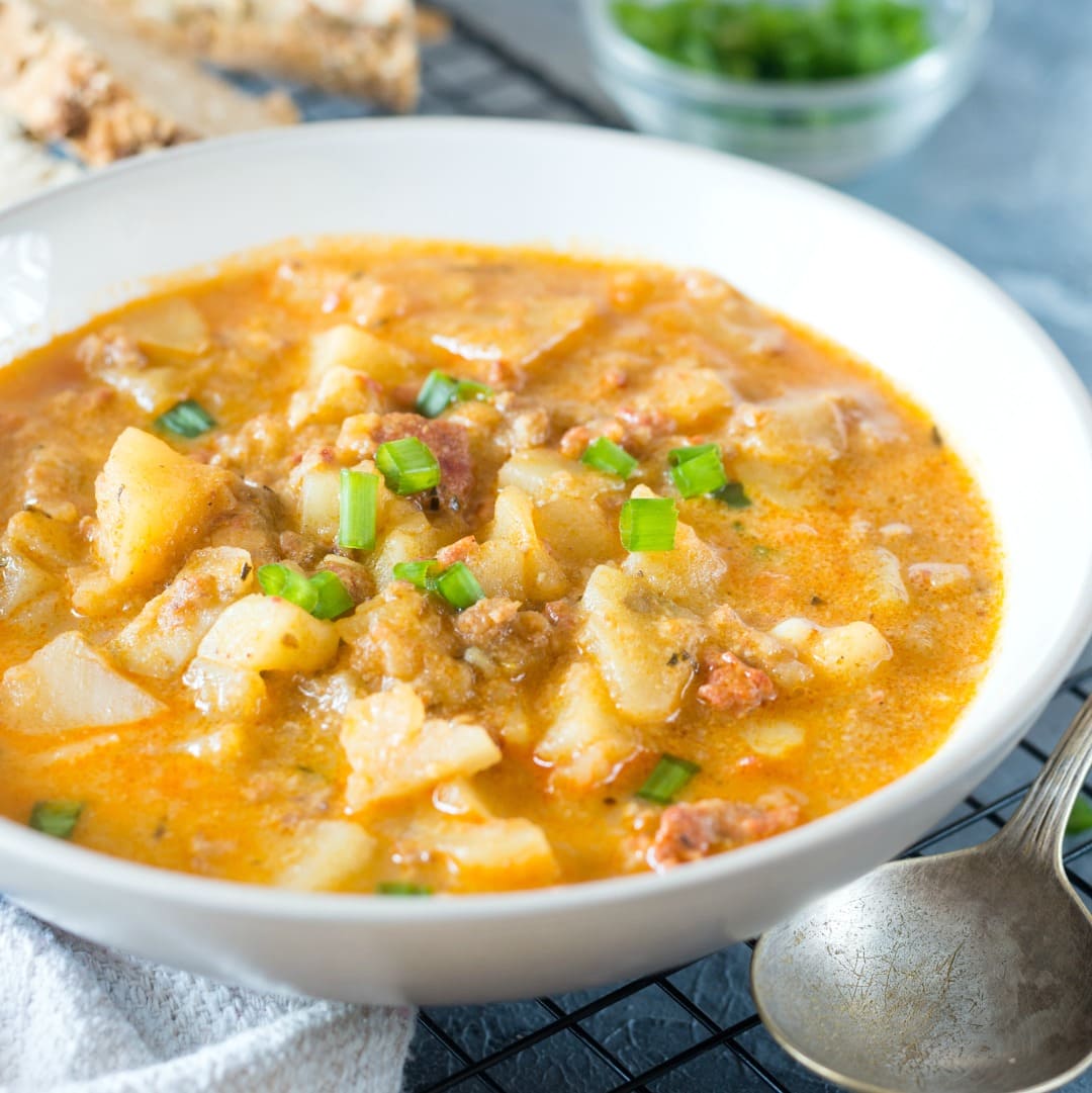 Close up view of creamy and flavorful potato soup made with chorizo and served in a white bowl.