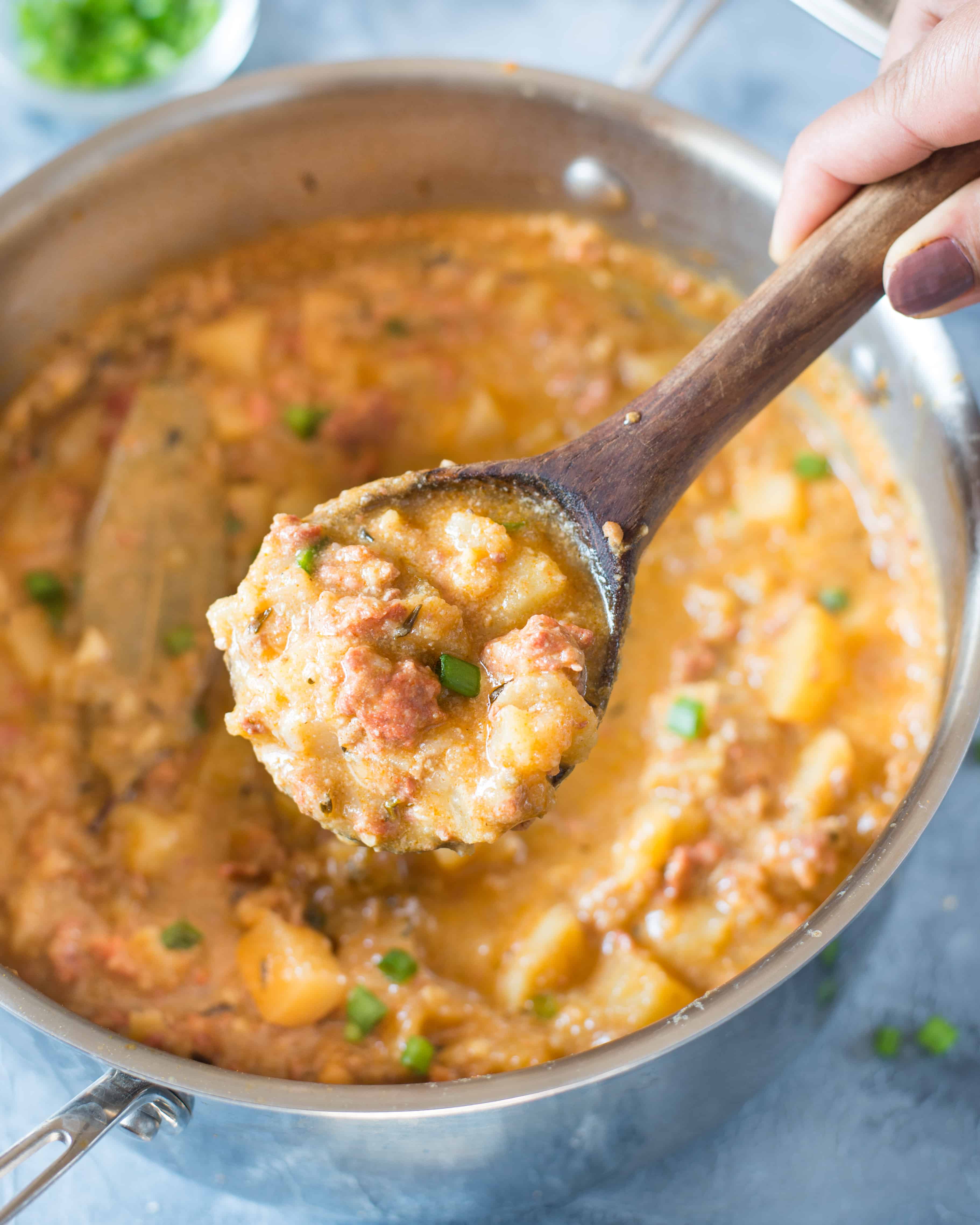 Close up shot of a ladle full of creamy and thick potato soup made with intensely flavorful chorizo.