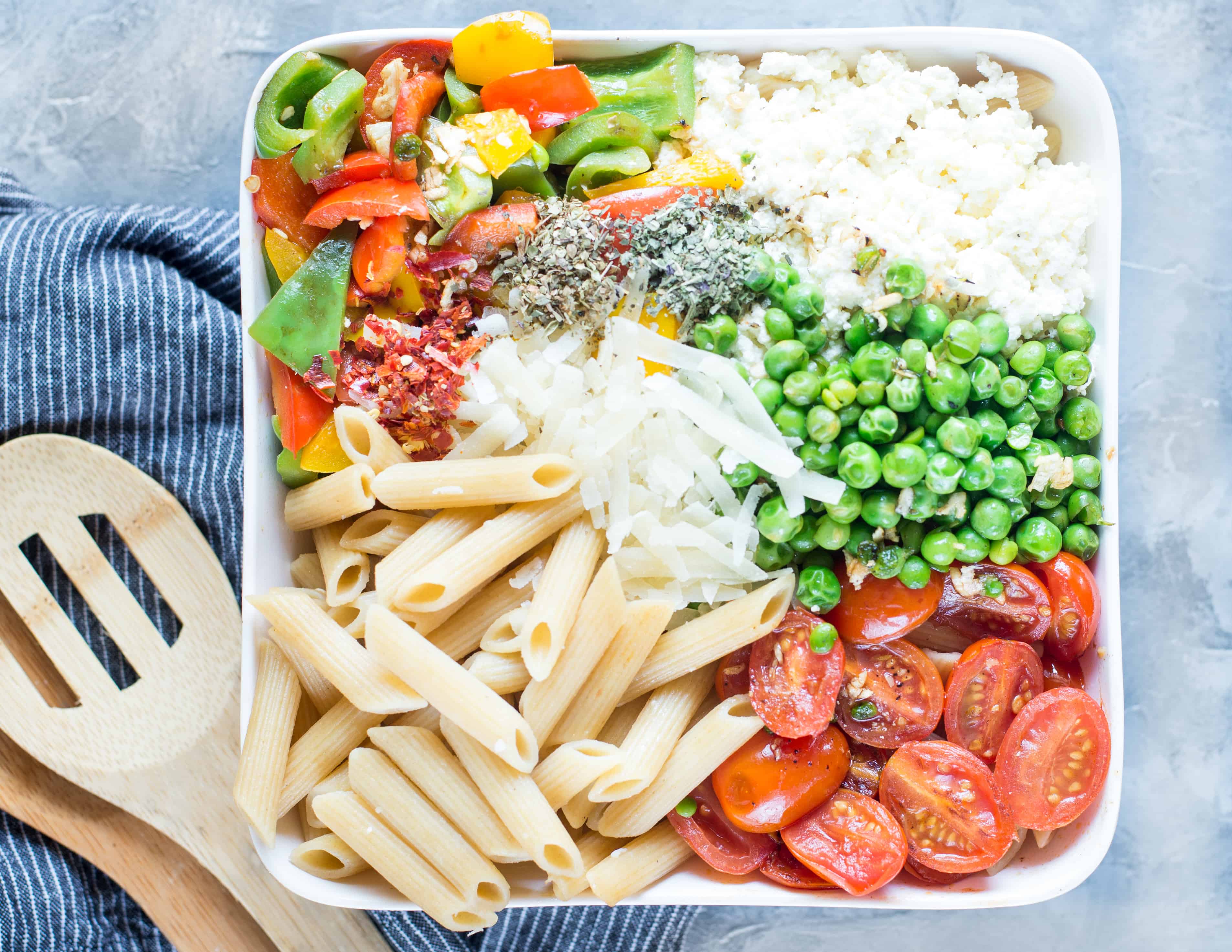 Ingredients include pasta, veggies, peas and cheese for making cold pasta salad.