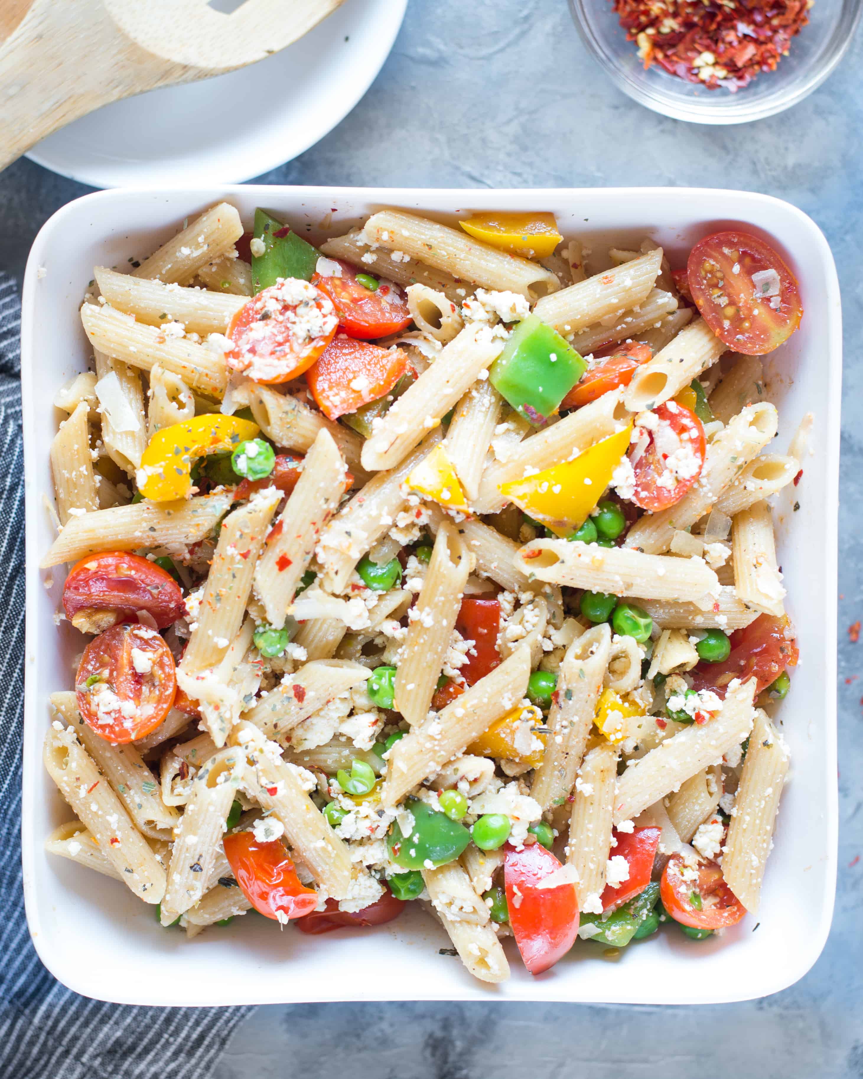 Top view of ricotta pasta salad, looking vibrant, served in a rectangular serving dish. 