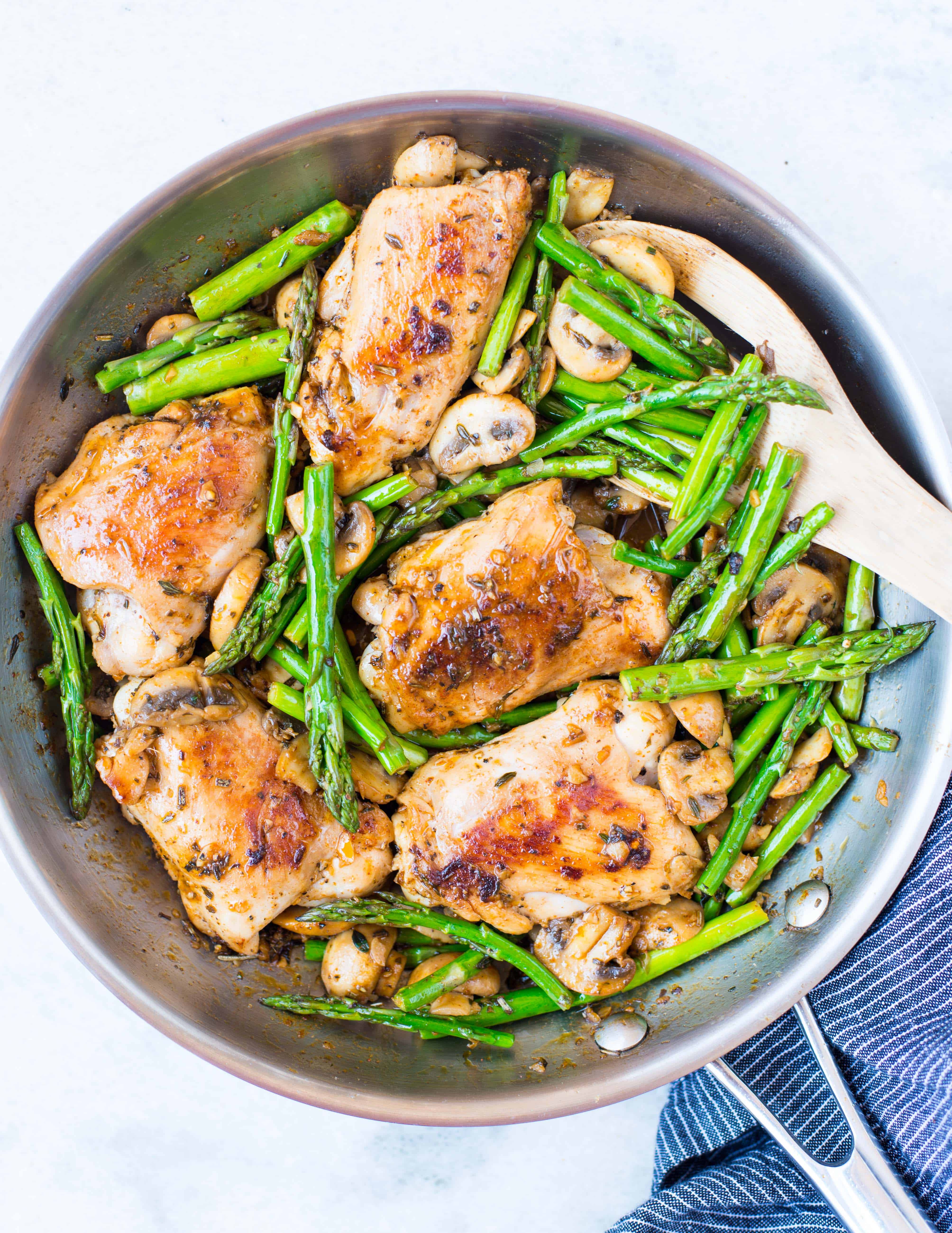 One-pan dish of chicken, asparagus and mushroom in a lemon butter herb sauce.