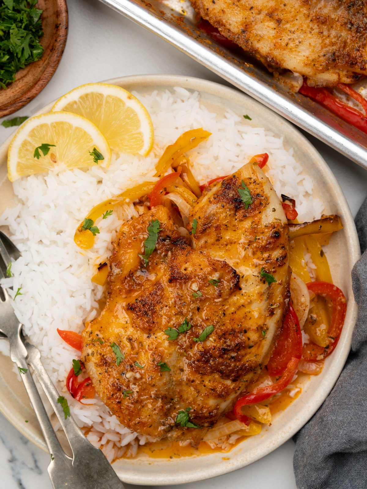 Tender baked tilapia, onion and peppers served on a bed of rice and slices of lemon. 