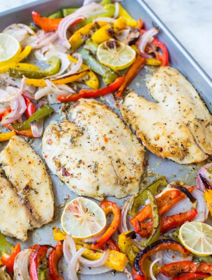 Baked Tilapia with onion and pepper in a delicious lemon garlic butter sauce. This Sheet Pan Lemon Garlic Baked Tilapia and Veggies is a healthy dinner made in under 20 minutes.