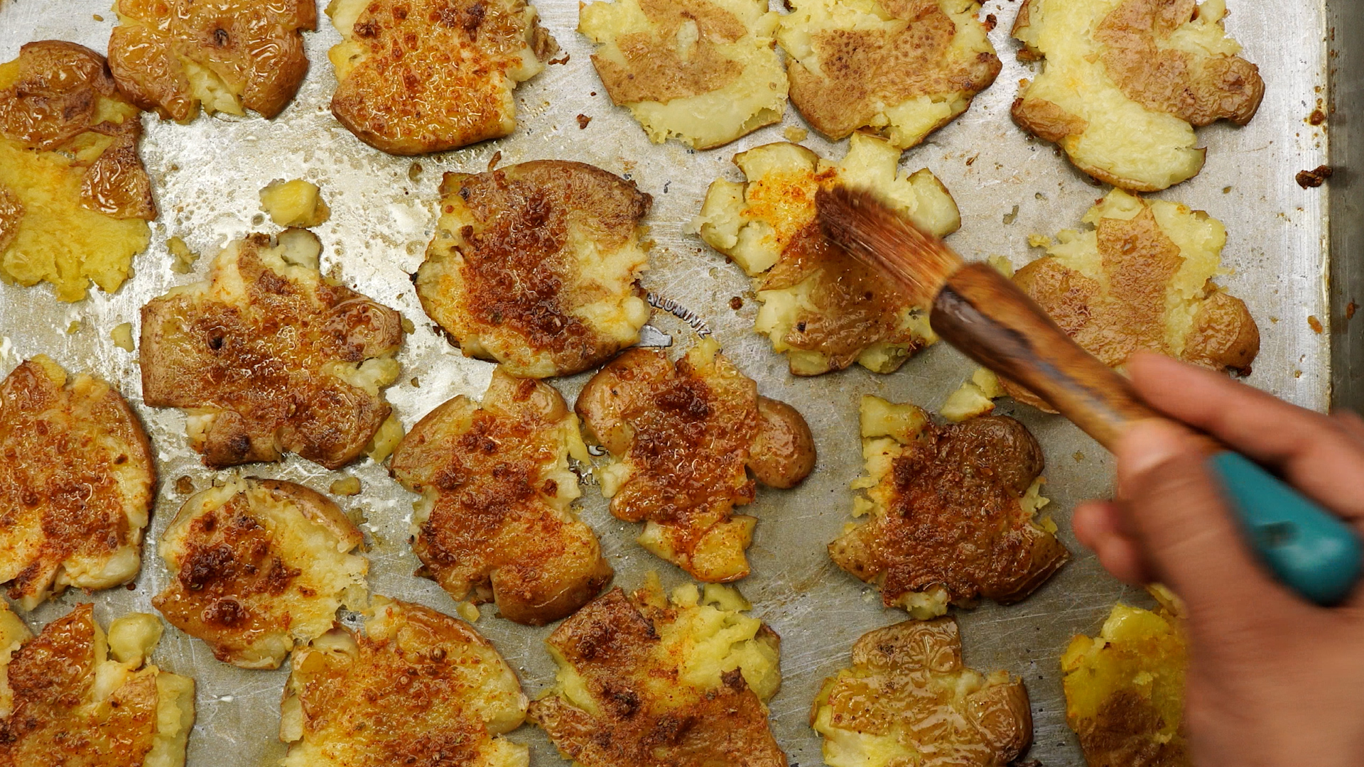 Brush cajun butter to partially baked smashed potatoes.