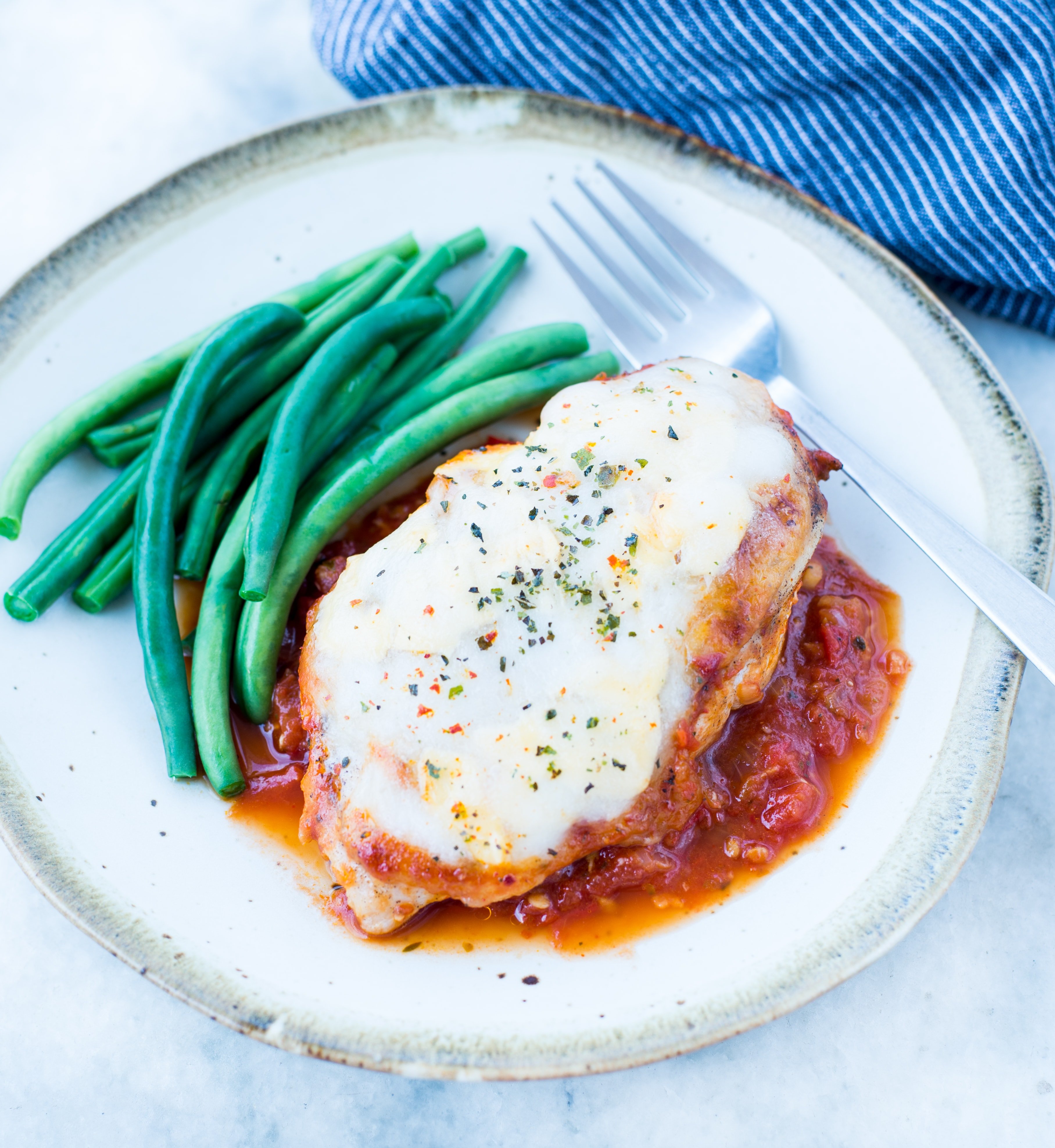 This Easy Mozzarella Chicken in homemade tomato sauce is low carb and made in one skillet. Pan Seared Chicken cooked in chunky tomato sauce and topped with gooey mozzarella is a perfect low carb dinner.