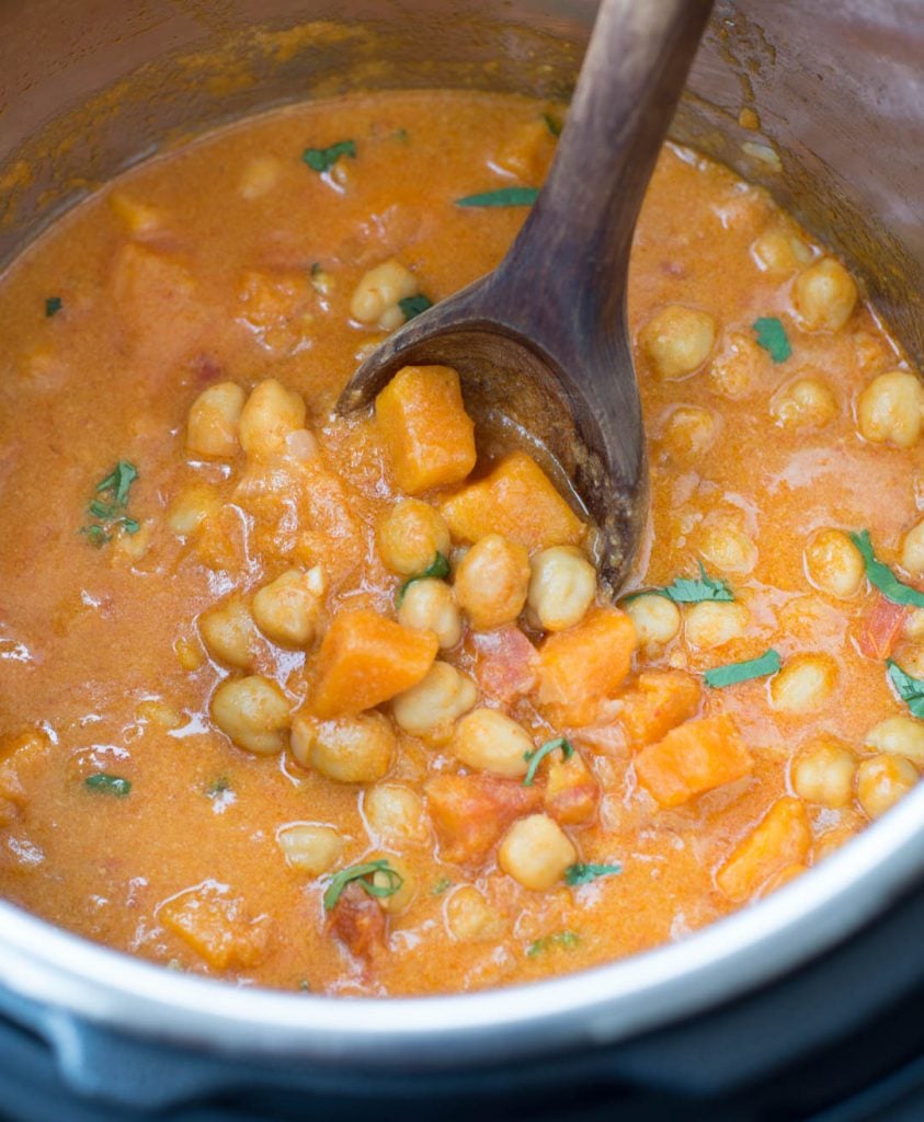Close view of sweet potato chickpea curry made in Instant Pot and picked with a ladle.
