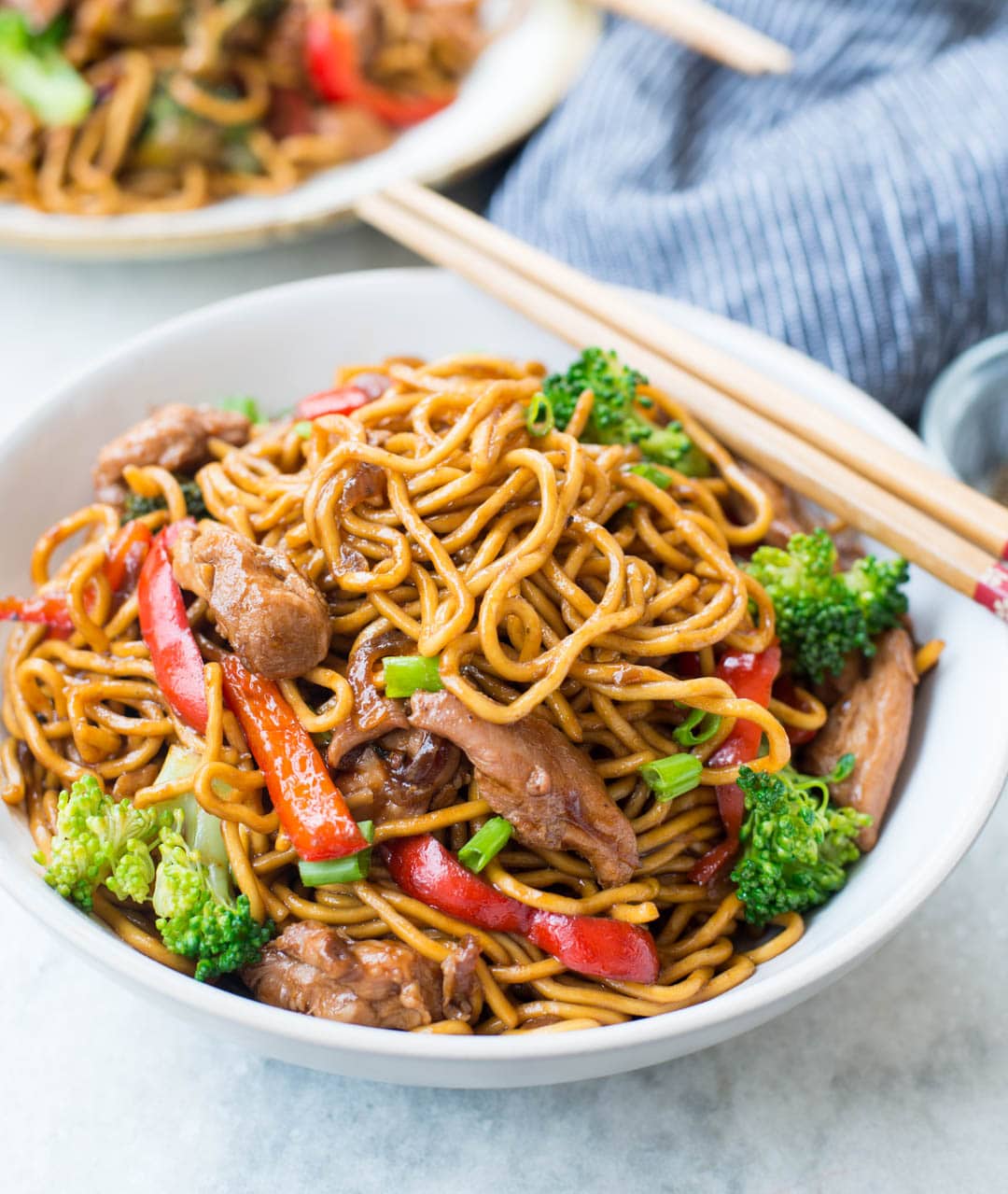 Close up shot of plated instant ramen noodles made with stir-fry sauce, brocolli, chili-peppers, chicken.