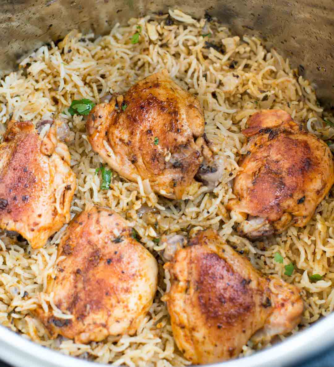 Garlic Herb Chicken and Rice made in the Instant Pot resulting in fluffy buttery rice and Juicy Chicken thighs. 