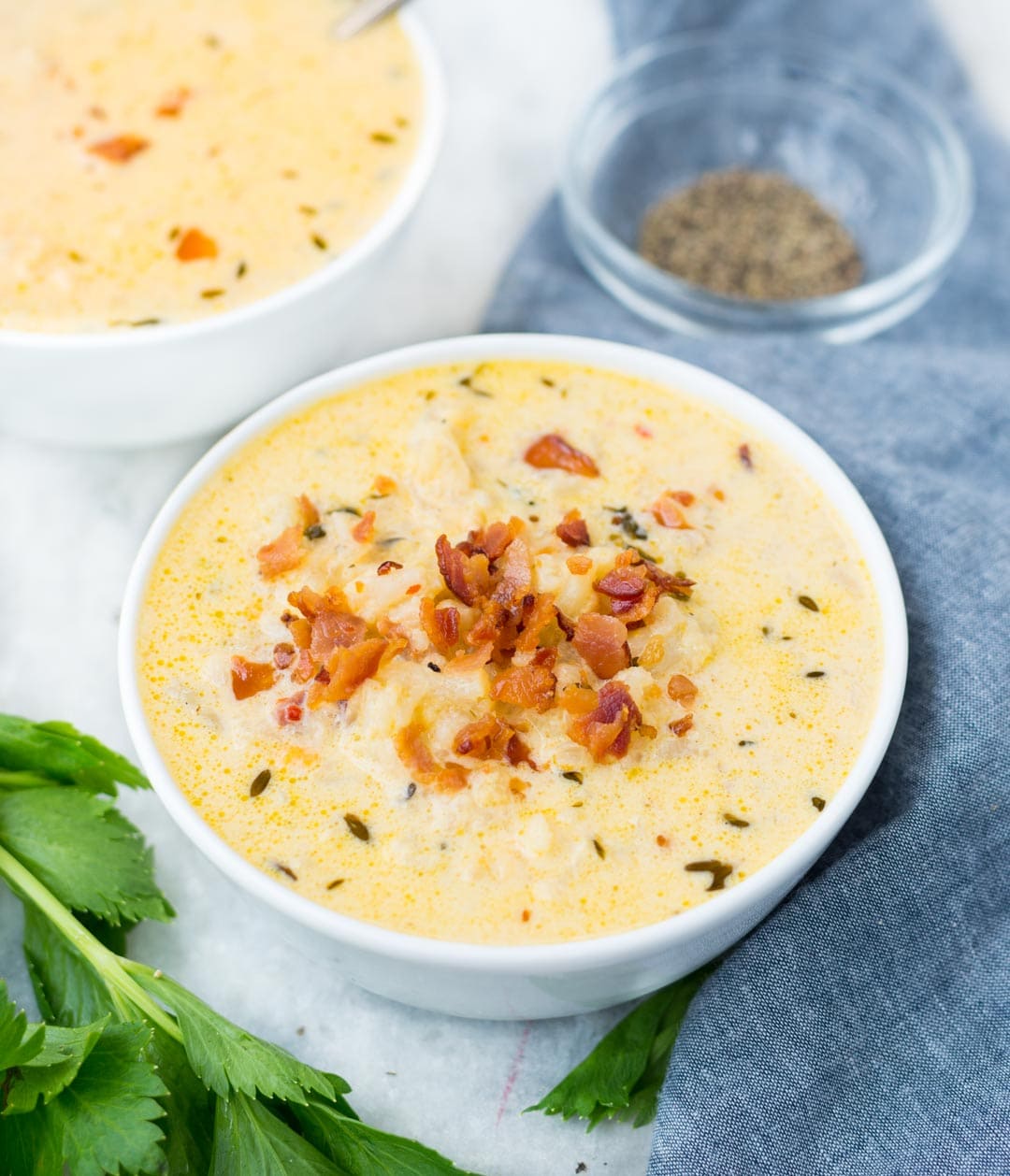 Closeup picture of Keto Cauliflower soup in a bowl shown with bacon bits garnished on top. 