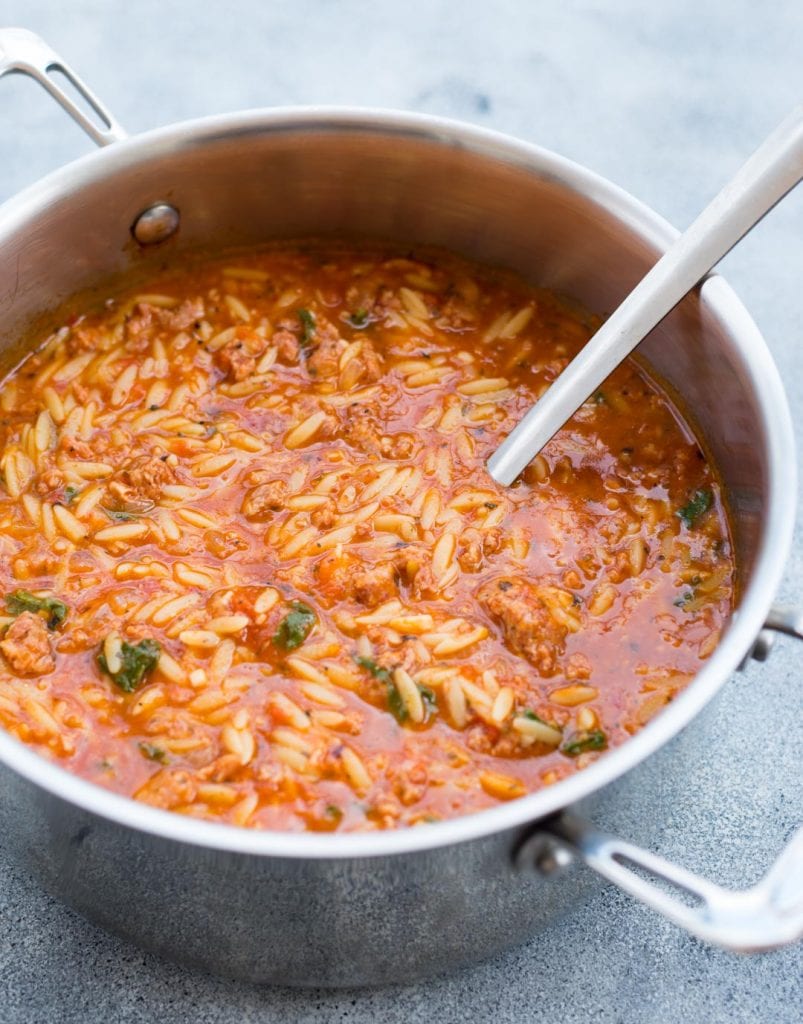 Orzo Soup made with Italian Sausage in a big pot and shown with a ladle