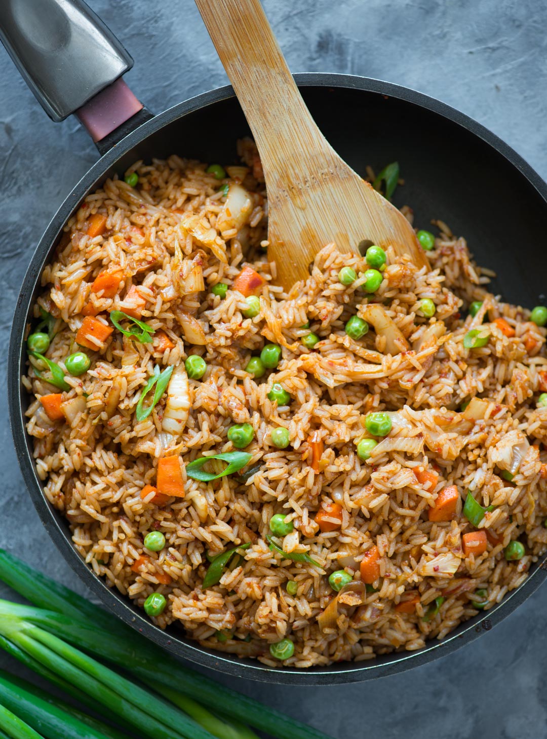 Kimchi Fried rice made in a pan with peas and green onions