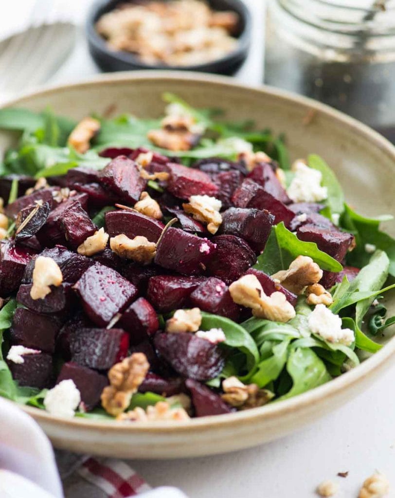 Side view of Beetroot Arugula Salad with walnuts in a bowl