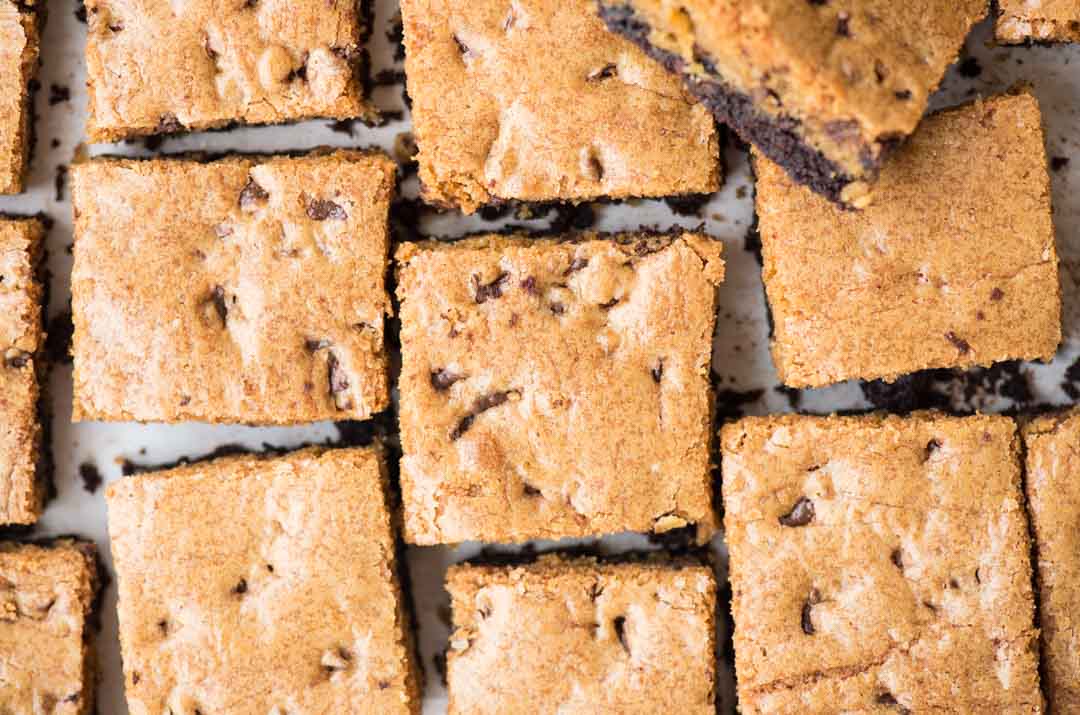 Double chocolate chip cookie bars with a fudgy chocolatey bottom are soft, chewy and made in a sheet pan. These Chocolate Chip Cookie Bars are made with single cookie dough (no separate dough for both the layers).