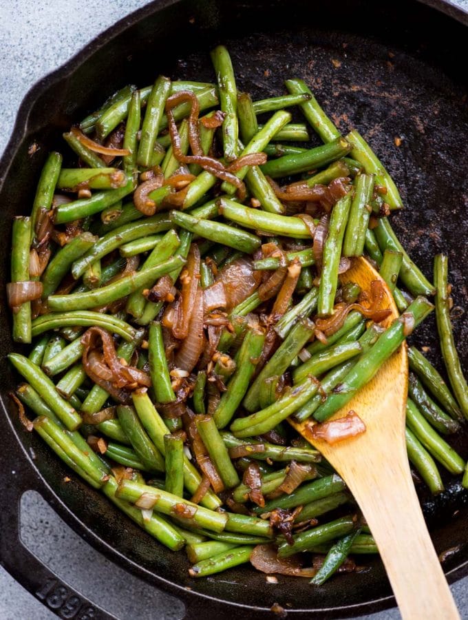 Asian Sauteed Green Beans with caramelized onion, garlic and a dash of soy sauce is an easy and versatile side dish. It takes only 20 minutes to make,the beans turn out tender and crispy.