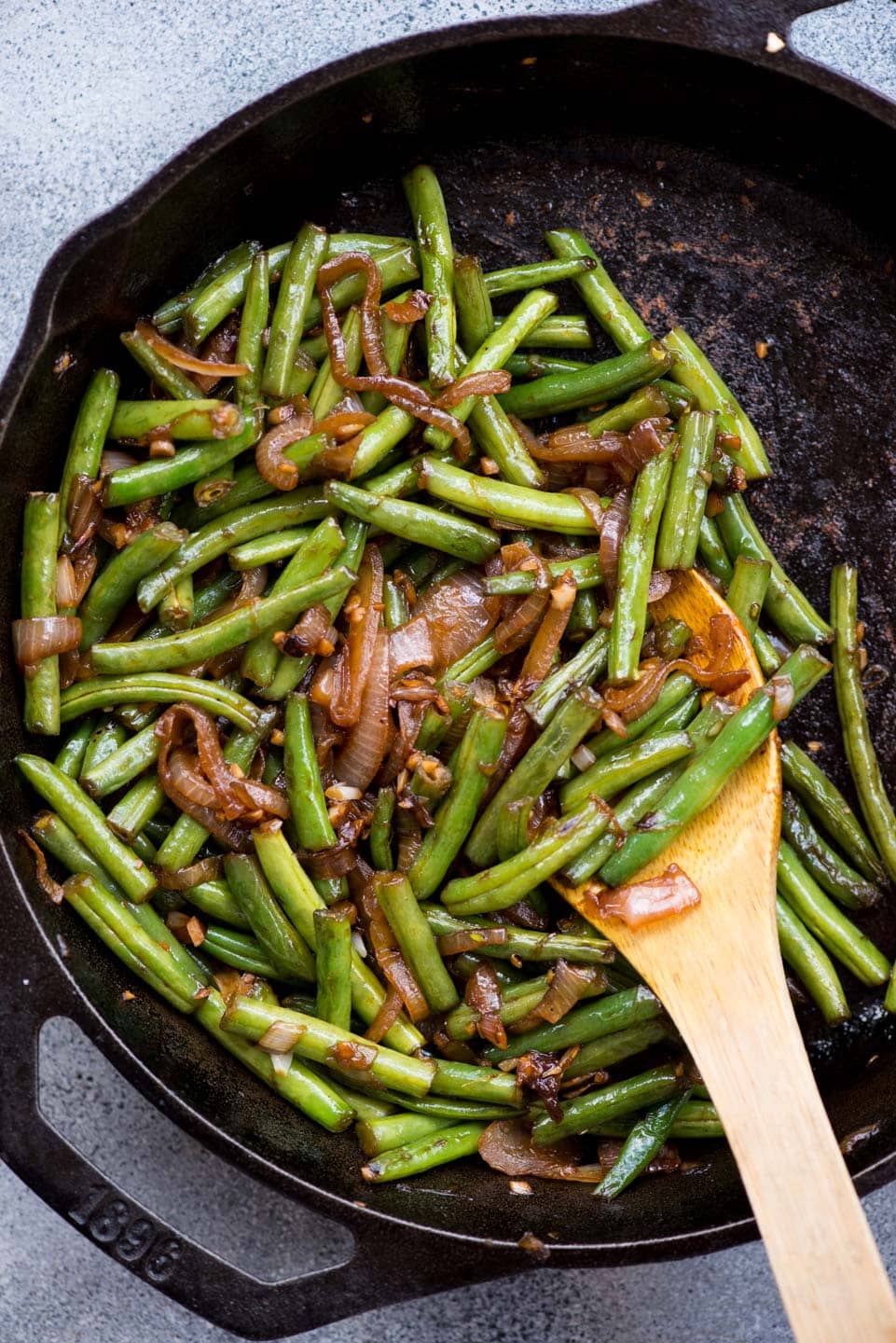 Asian Sauteed Green Beans with caramelized onion, garlic and a dash of soy sauce is an easy and versatile side dish. It takes only 20 minutes to make,the beans turn out tender and crispy.
