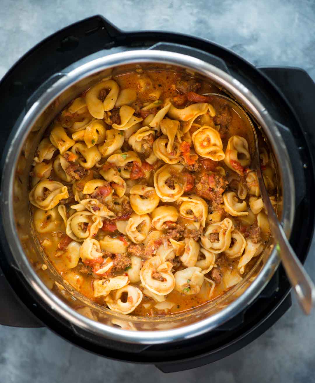 Rich and cheesy tortellini sausage soup is made in an instant pot 