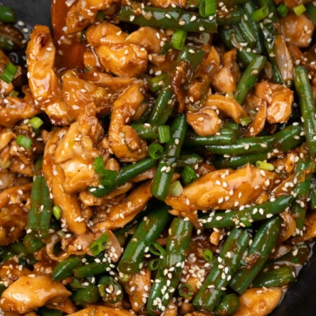 strips of chicken thighs and green beans is stir fried in a quick Asian stir fry sauce, garnished with toasted sesame seeds