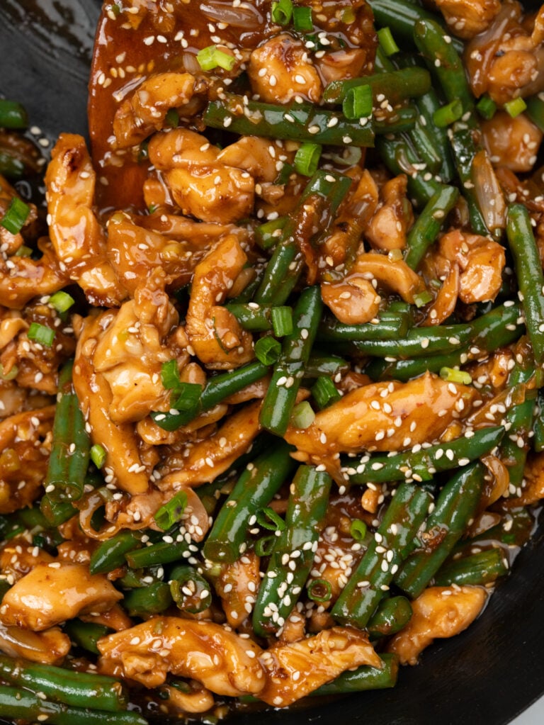 strips of chicken thighs and green beans is stir fried in a quick Asian stir fry sauce, garnished with toasted sesame seeds