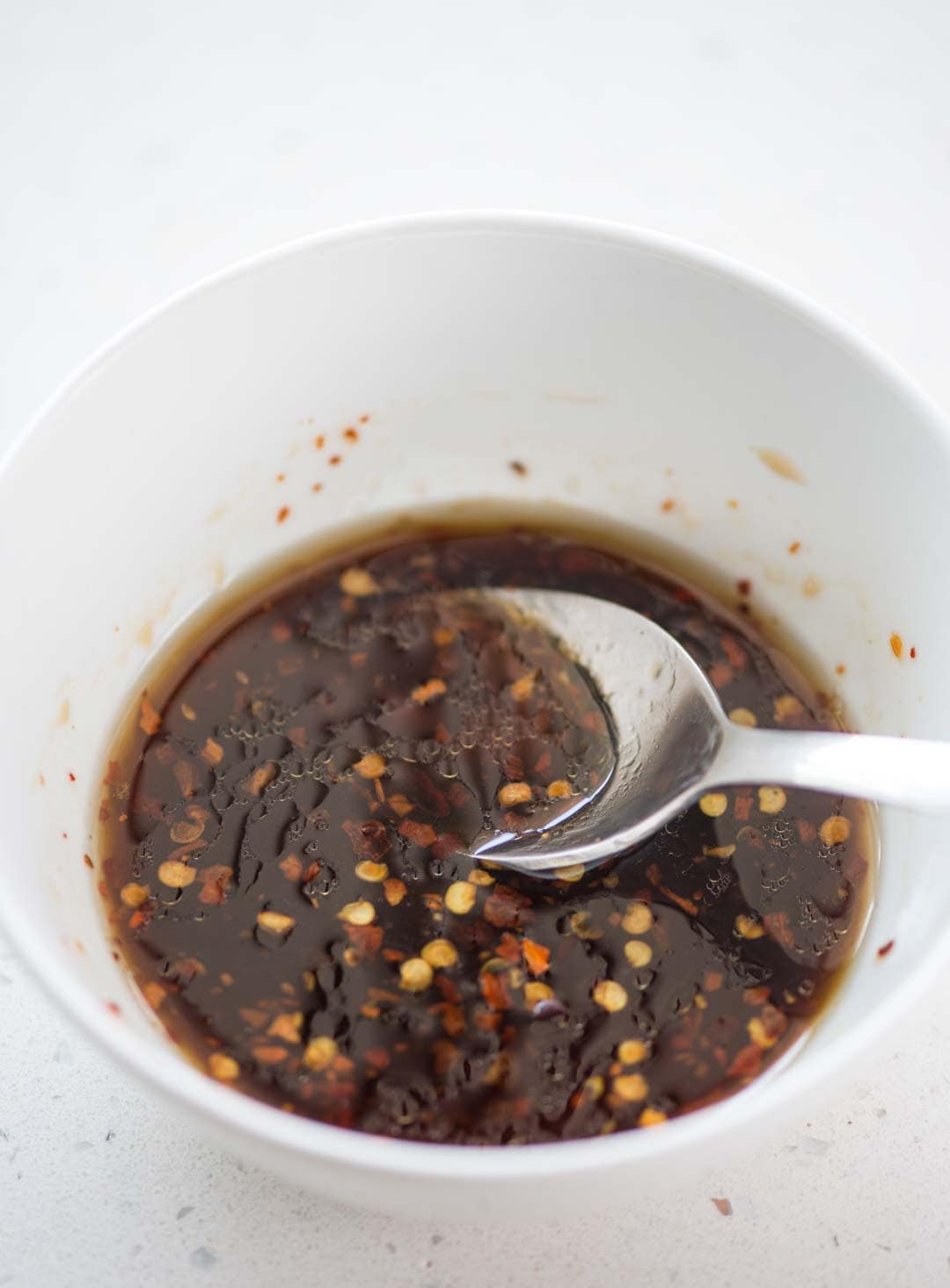 A bowl of sweet and tangy salad dressing with a little heat used to drizzle in a variety of salads