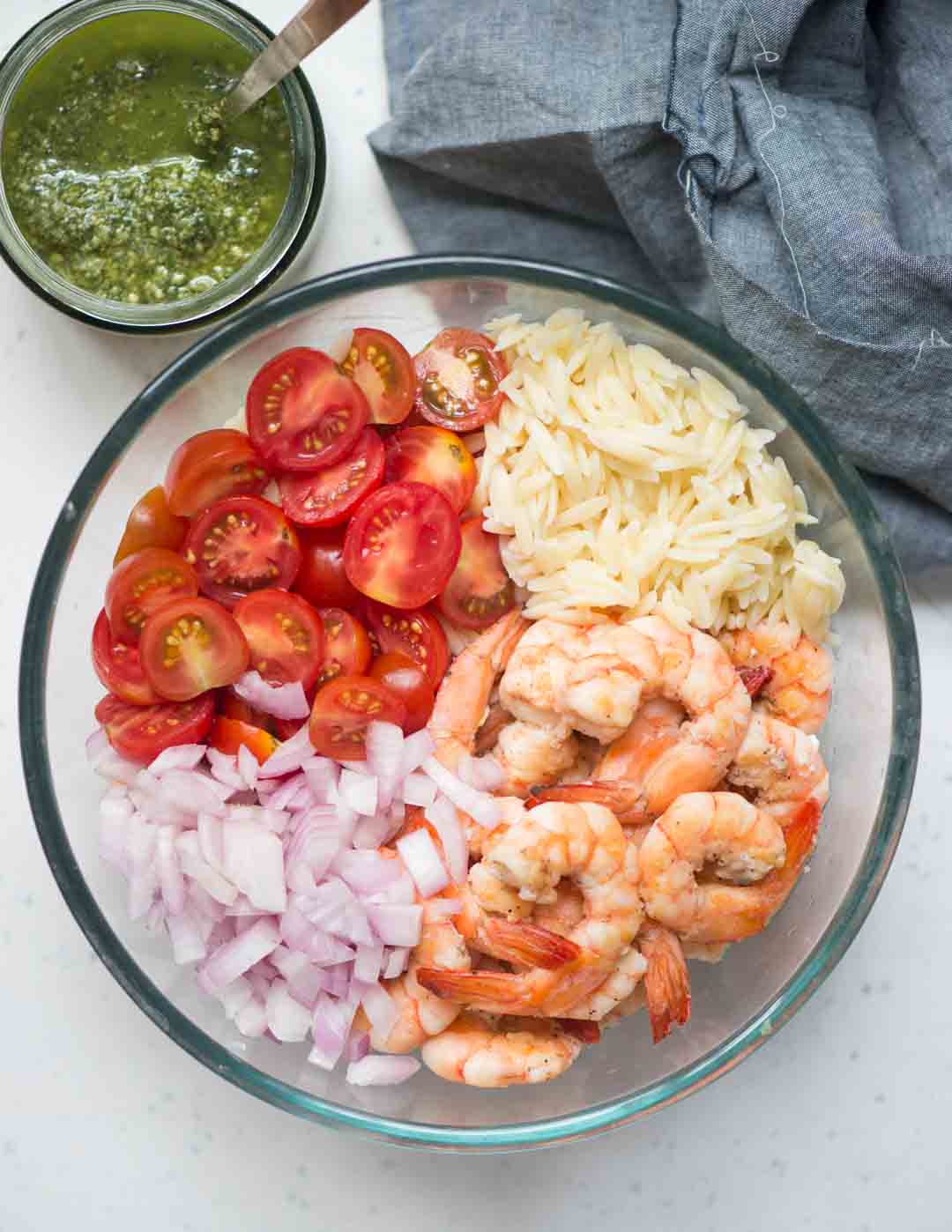 Toss orzo pasta, cherry tomatoes, Chopped onion, shrimp in basil pesto, for a refreshing summer salad