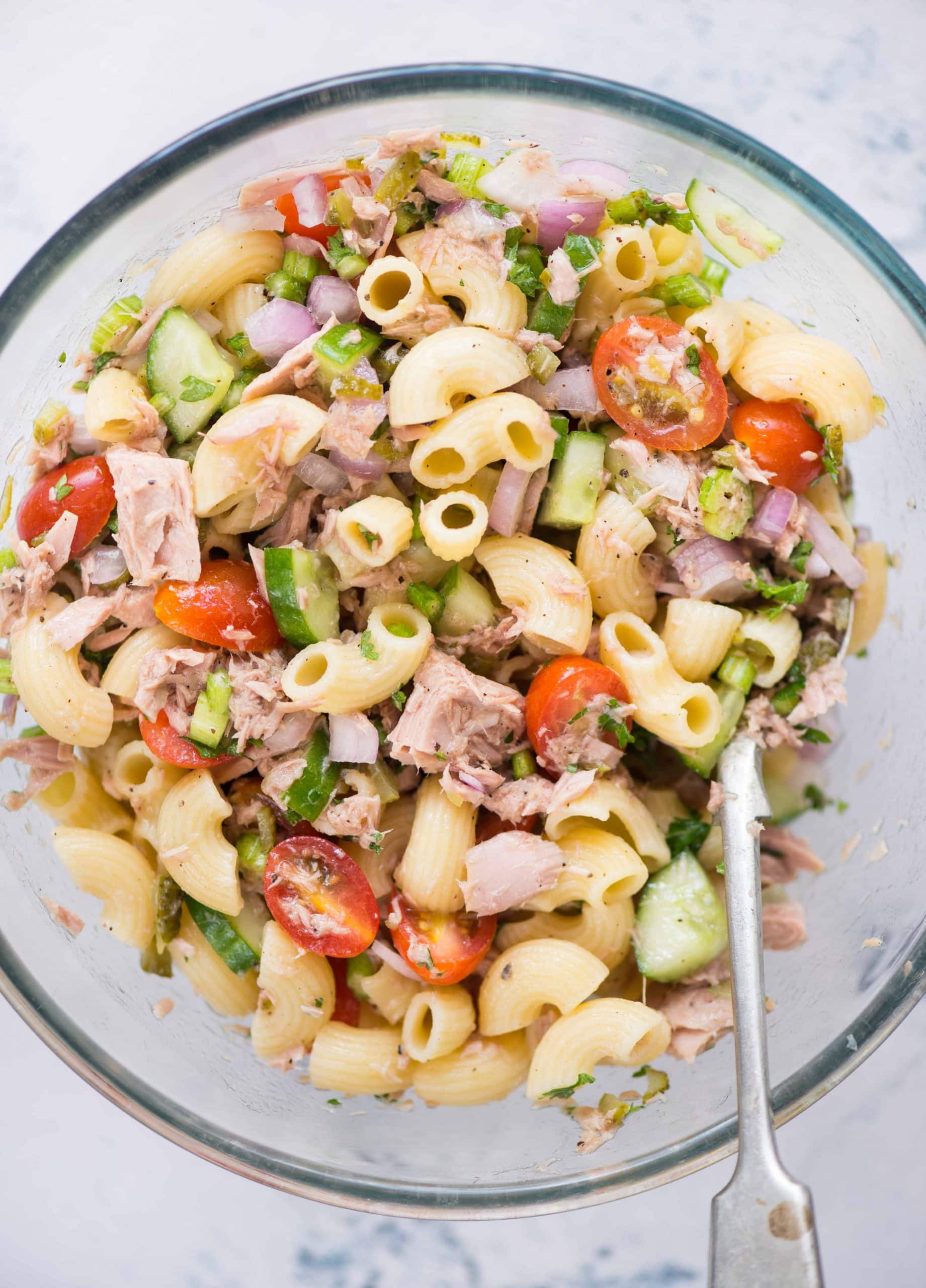 Cold tuna pasta salad served in a bowl with macaroni, tuna, chopped veggies tossed with olive-oil vinaigrette.