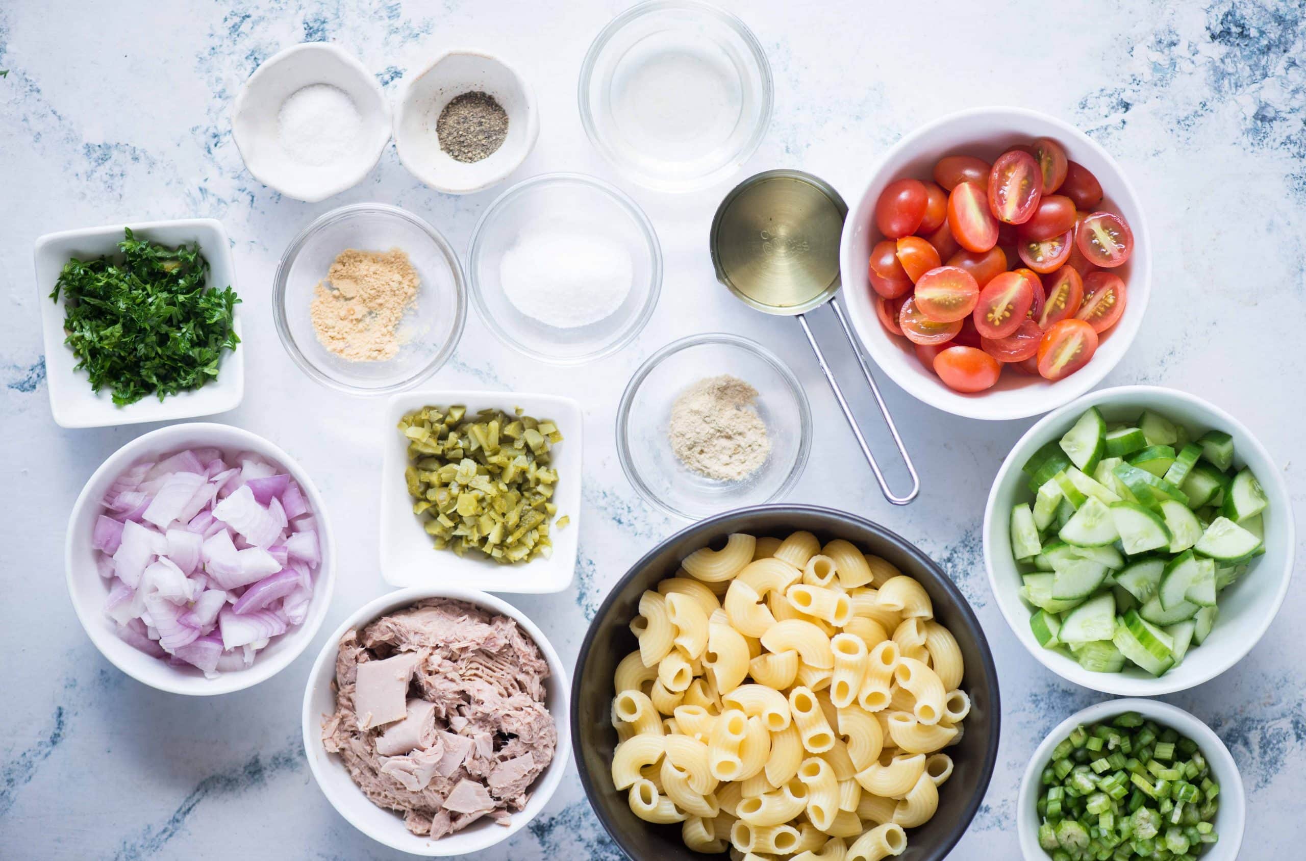 Ingredients for tuna pasta salad laid out on a table.