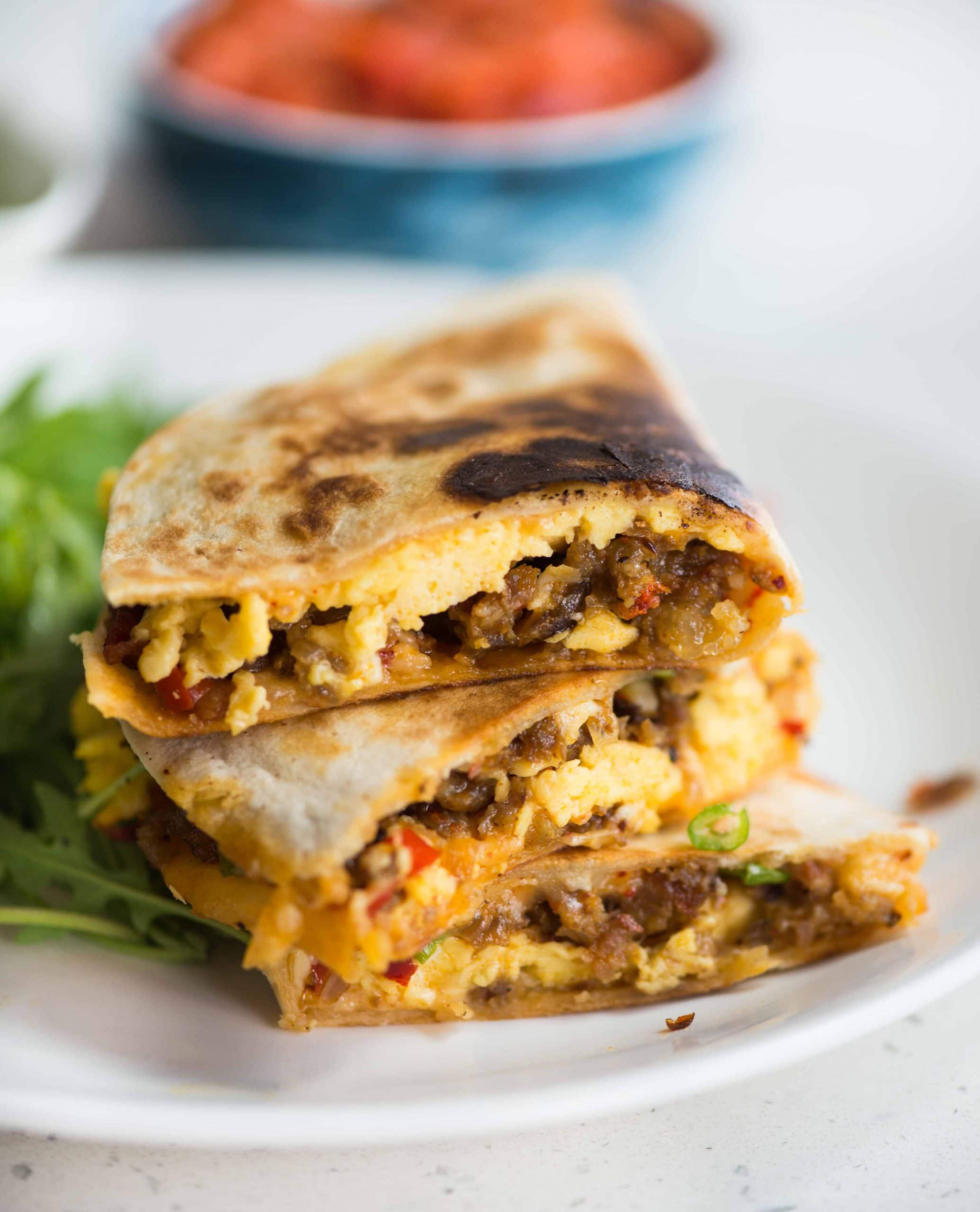 Crispy Tortilla filled with soft scrambled eggs, cheese, breakfast sausage, and bacon, Breakfast quesadilla is easy and quick to make. These quesadillas are perfect for breakfast, brunch, or even dinner.