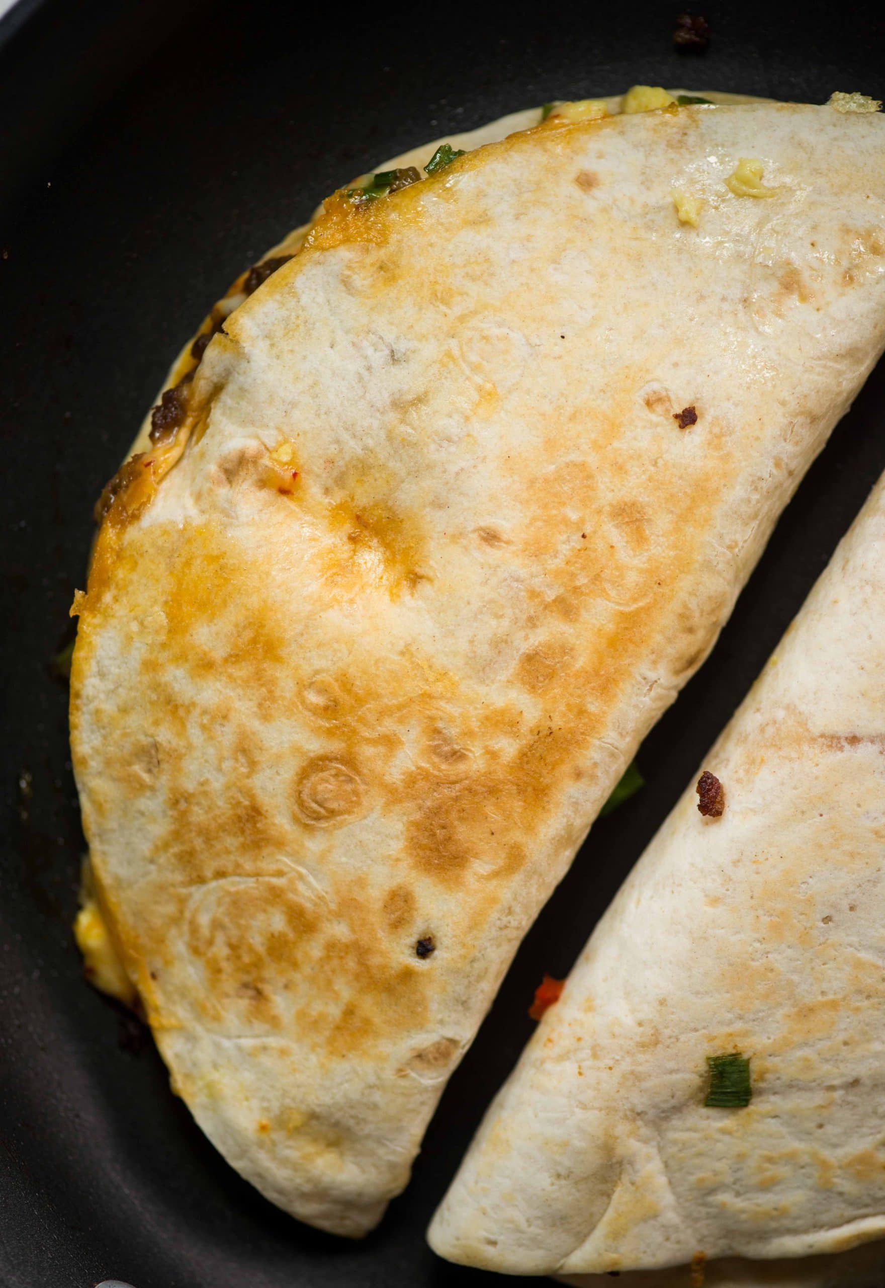 Crispy Tortilla filled with soft scrambled eggs, cheese, breakfast sausage, and bacon, Breakfast quesadilla is easy and quick to make. These quesadillas are perfect for breakfast, brunch, or even dinner.