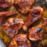 Sweet, smoky flavors of Chicken baked in the oven on a tray with a BBQ sauce