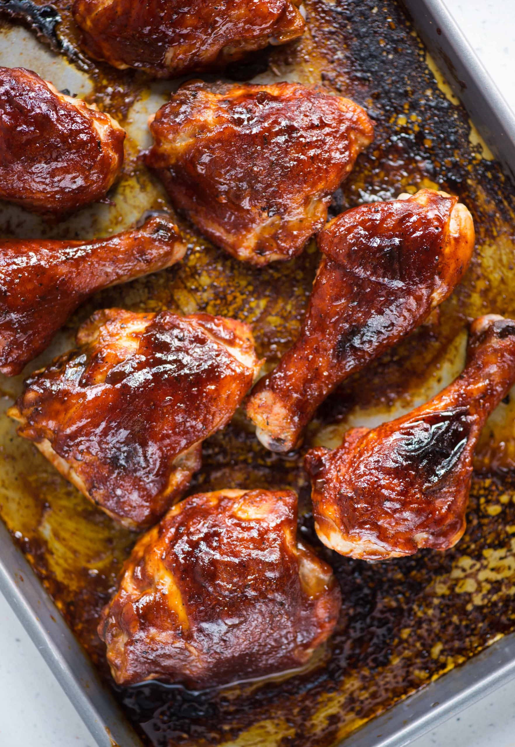 Sweet, smoky flavors of Chicken baked in the oven on a tray with a BBQ sauce