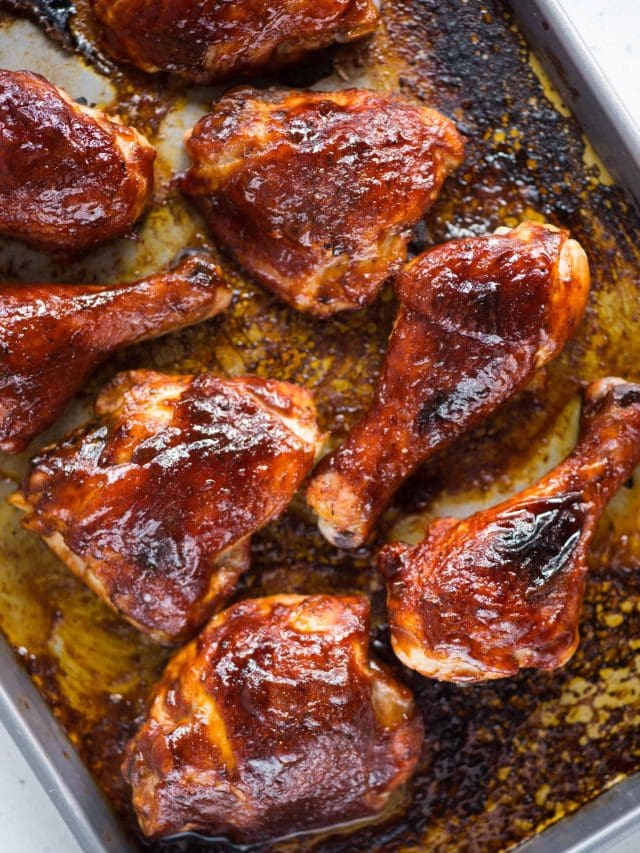 Sweet, smoky flavors of Chicken baked in the oven on a tray with a BBQ sauce