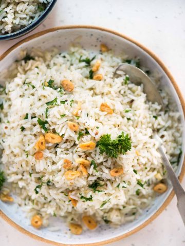 Garlic butter rice with a subtle flavor from parsley, this is a perfect side dish to serve. The rice is perfectly seasoned and smells heavenly of garlic butter.