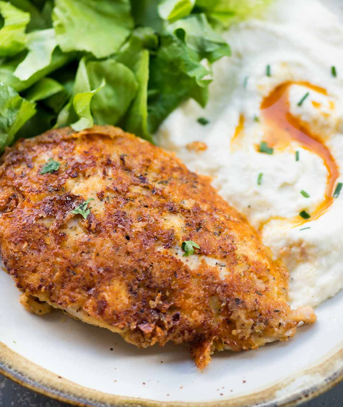 Perfectly crispy Chicken crusted with parmesan and served with fresh greens and mashed potato