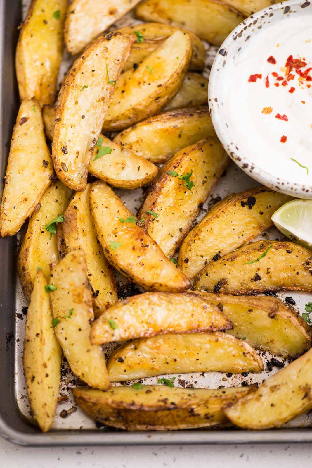 Potato wedges tossed in a Greek marinade and baked in the oven until crispy and golden. 