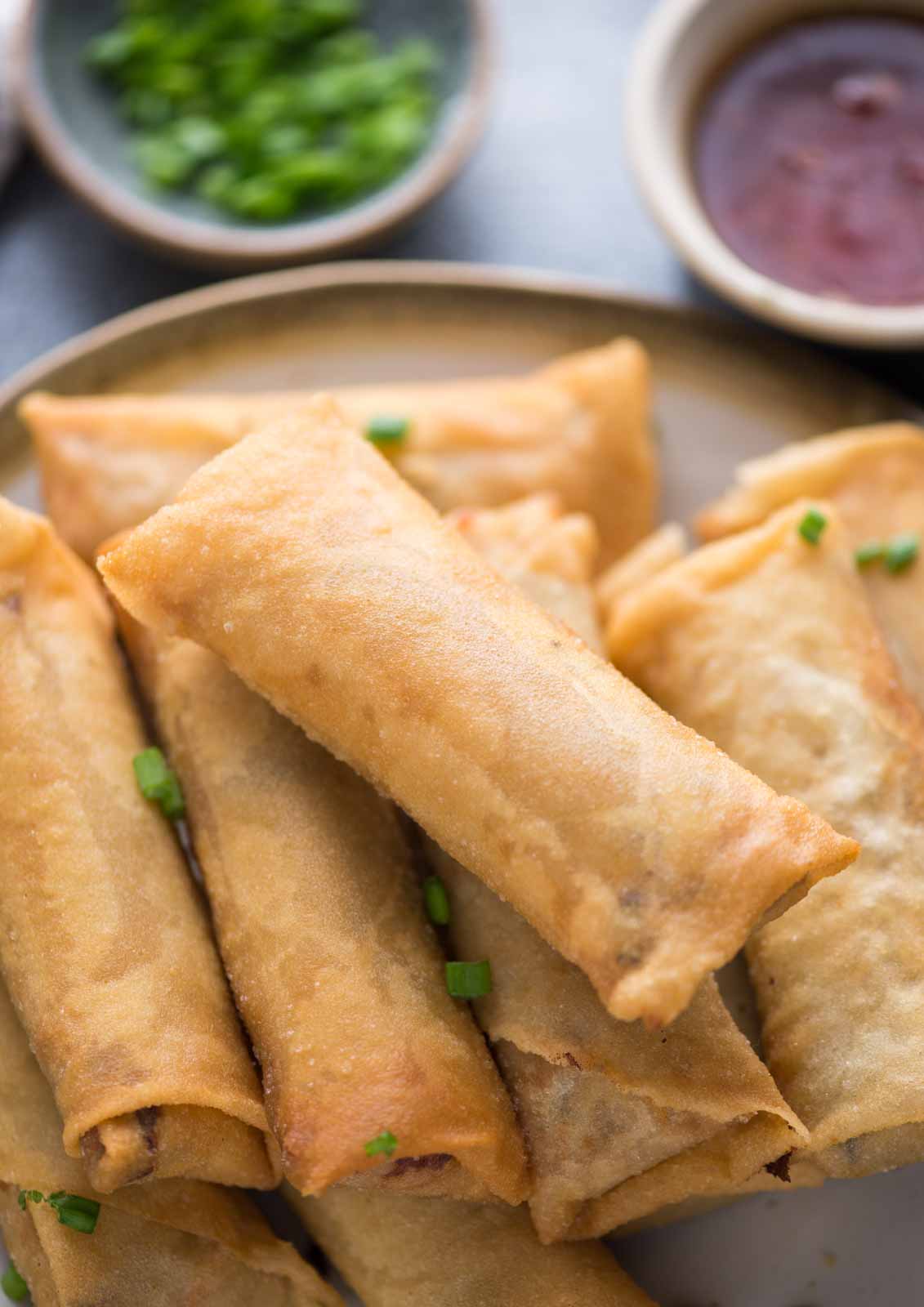 A plate of chicken spring rolls done in both ways - Air-fried and deep-fried, with dipping sauce. Flaky and shatteringly crispy.