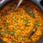 Chana dal garnished with coriander leaves and prepared with spices in a pressure cooker