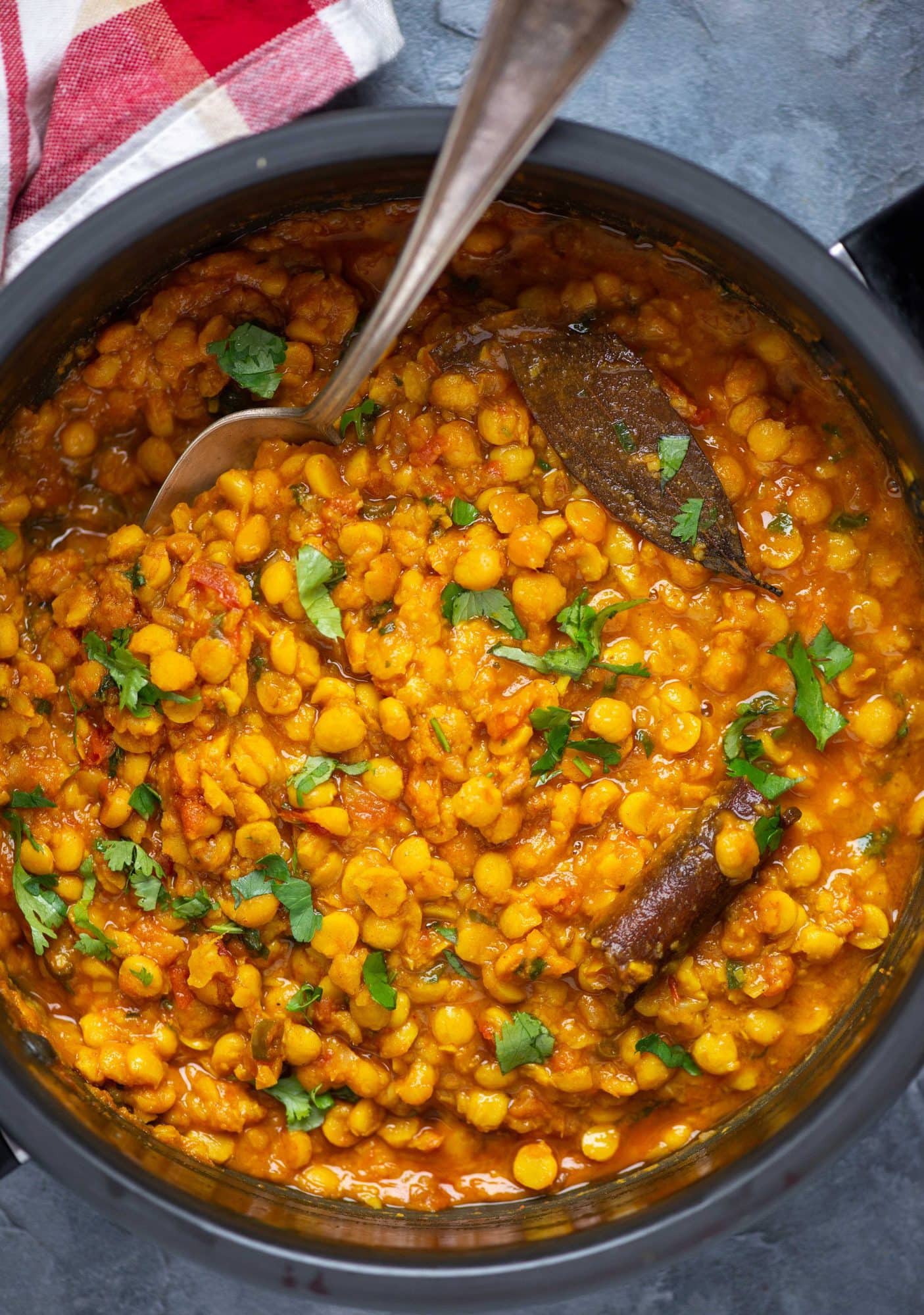 Chana dal garnished with coriander leaves and prepared with spices in a pressure cooker