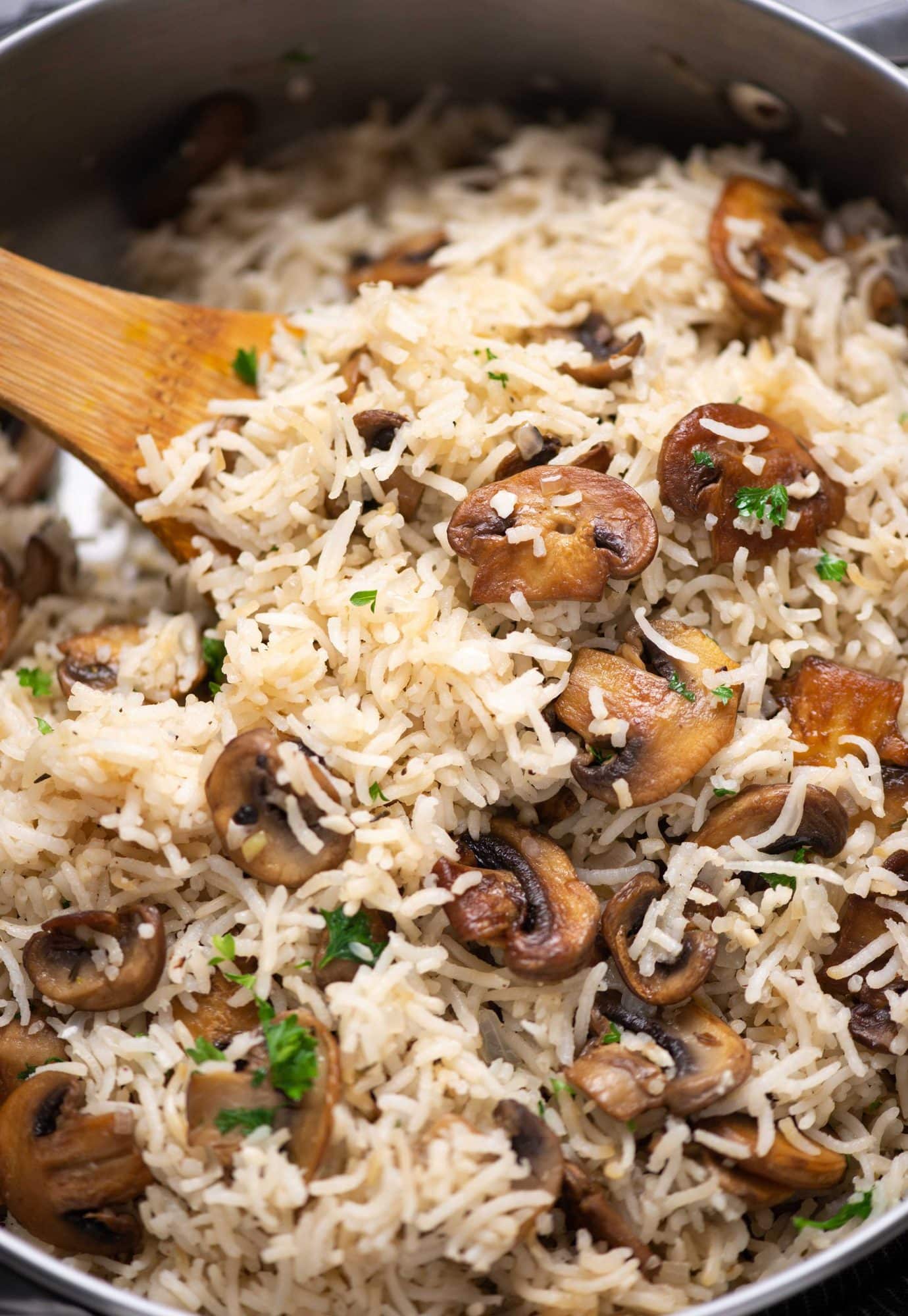 Close-up picture of Mushroom rice garnished with fresh parsley and browned mushroom.