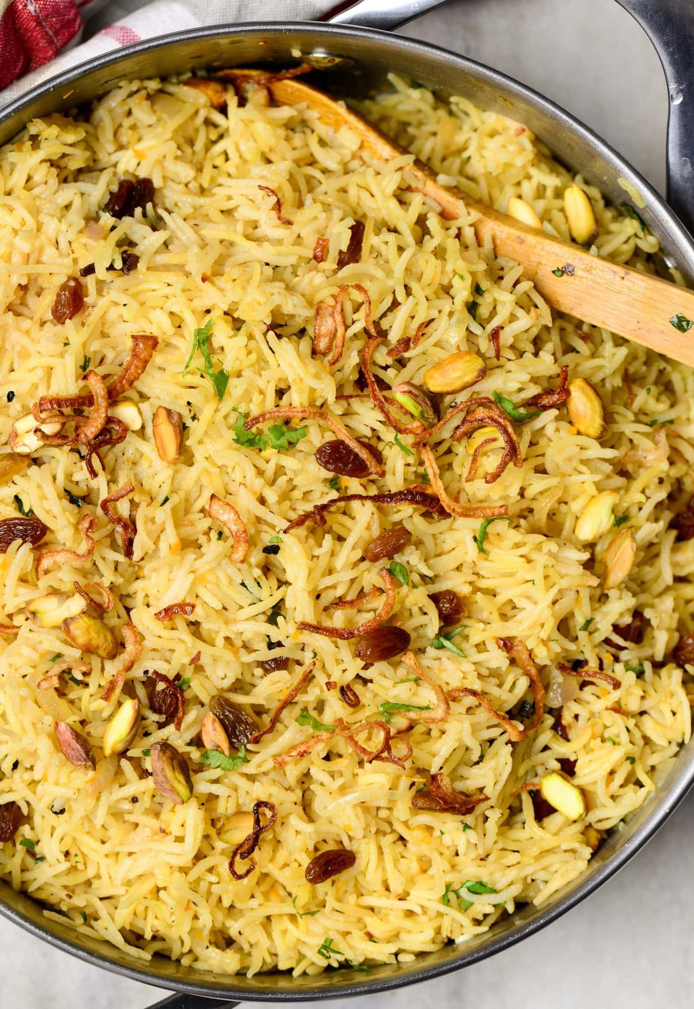 Rice Pilaf made in a dutch oven in butter with mild spices and dry fruits, nuts and garnished with caramelized onions.