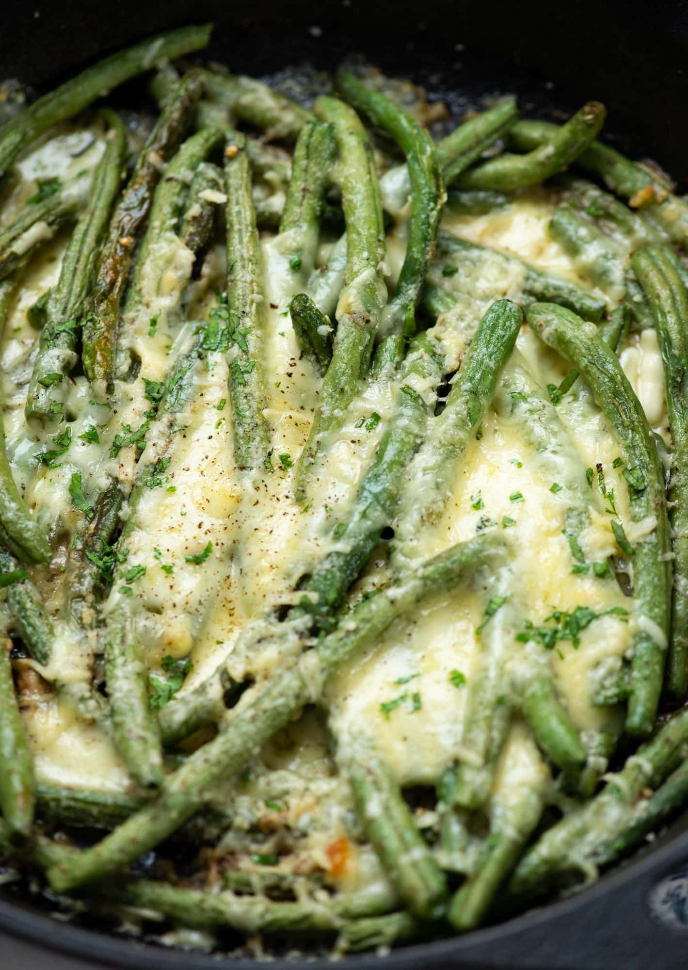 Close up of cheesy garlic roasted green beens on a plate