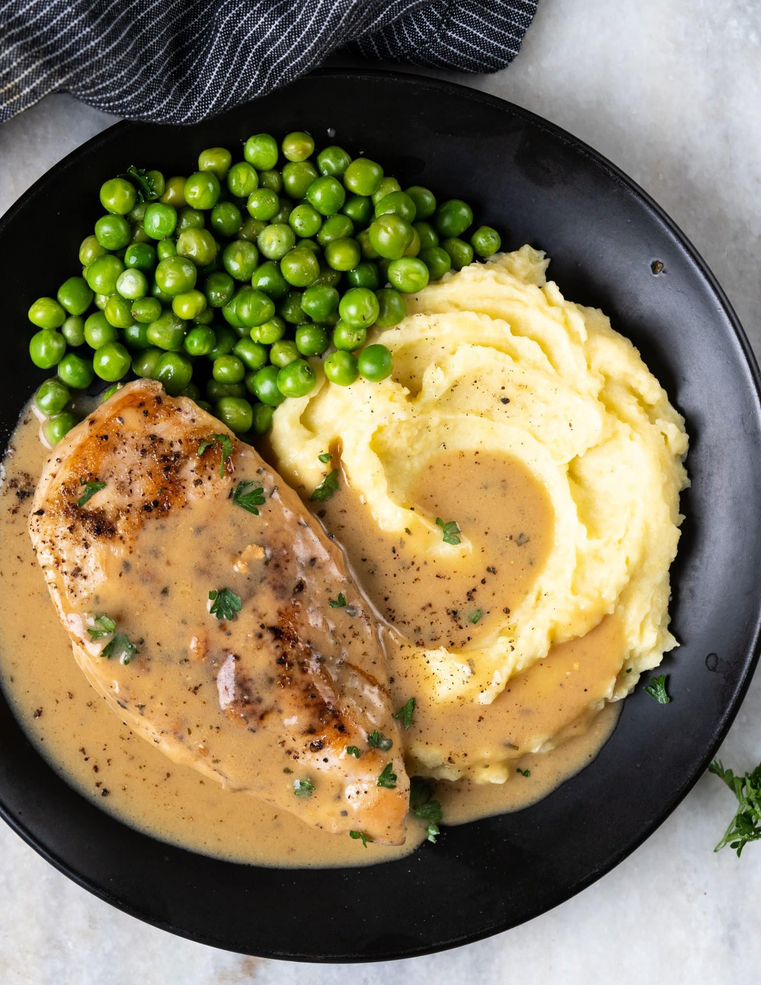 Ranch chicken is served on mashed potato along with sauteed green peas.