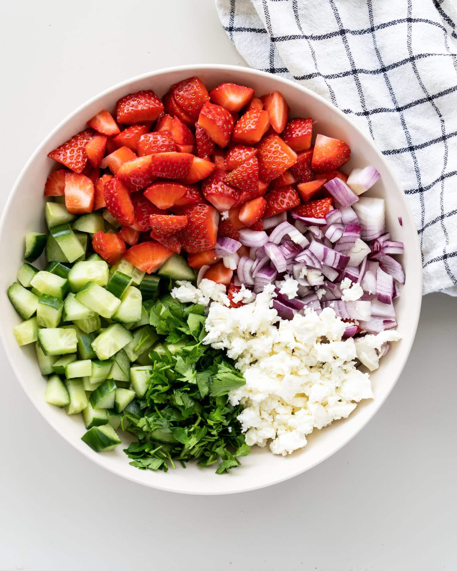 Ingredients for strawberry cucumber salad - chopped strawberry, cucumber, mint leaves, feta cheese