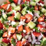 Strawberry cucumber salad with cheese and onions in a bowl