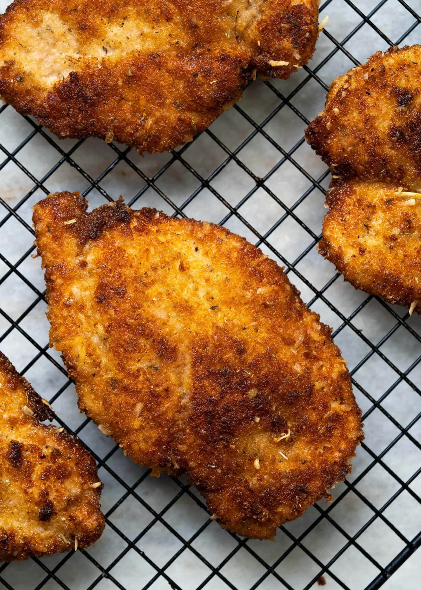 Chicken cutlets shallow fried and rested on a wire rack to keep it crisp